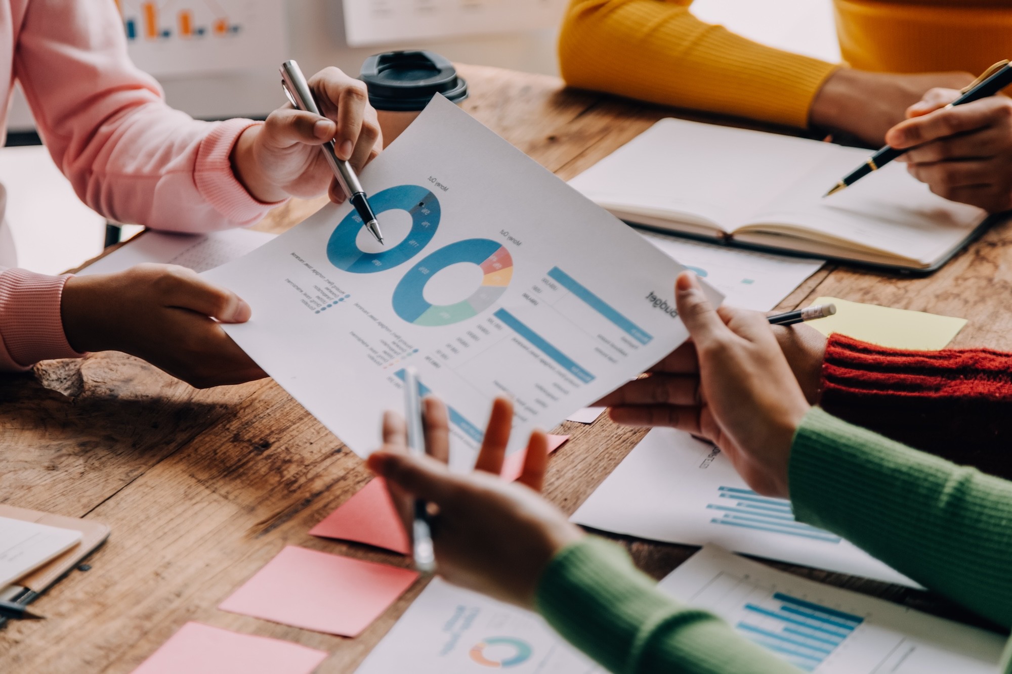 Financial analysts analyze business financial reports on a digital tablet planning investment project during a discussion at a meeting of corporate showing the results of their successful teamwork.